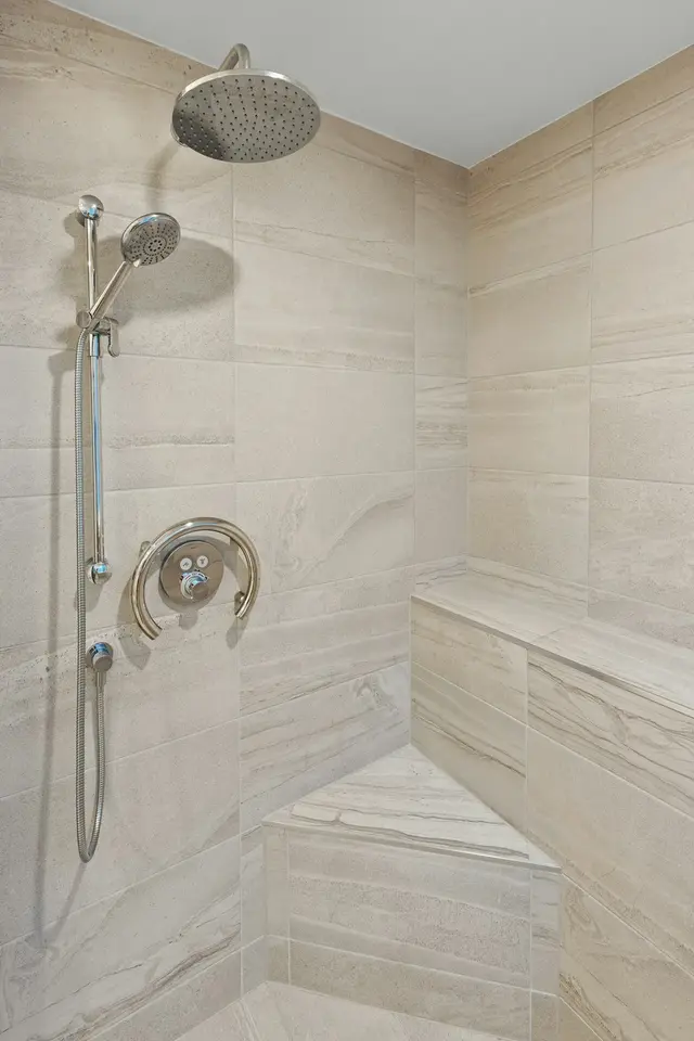Walk-in shower with a tiled corner bench