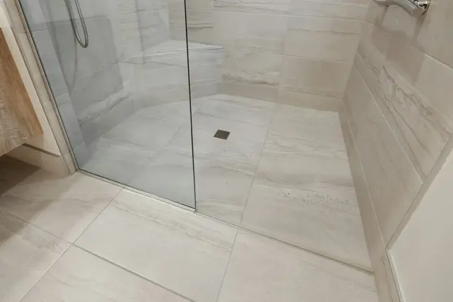 Large-format porcelain floor into a glass shower