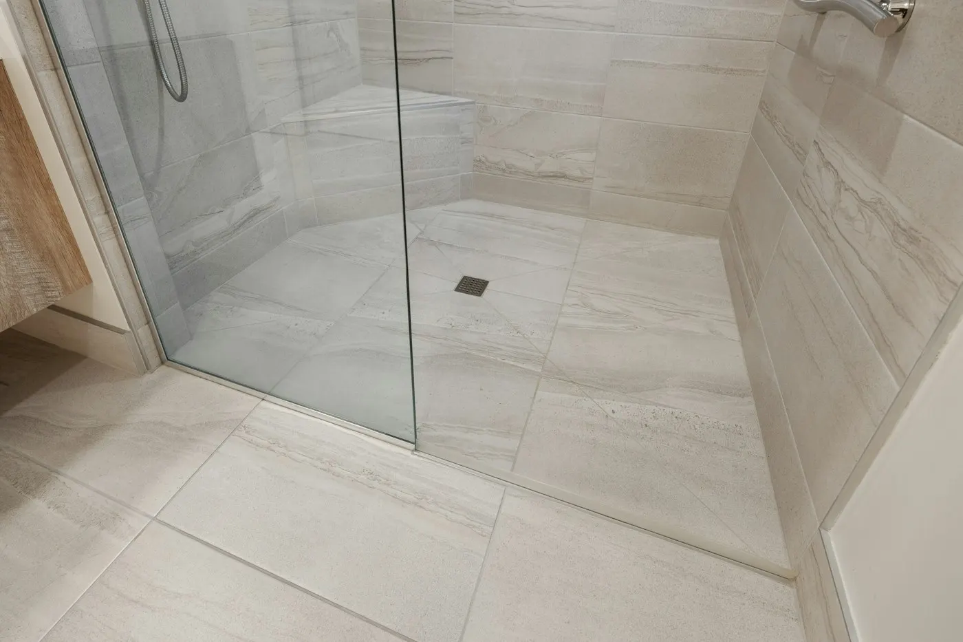 Large-format porcelain floor into a glass shower
