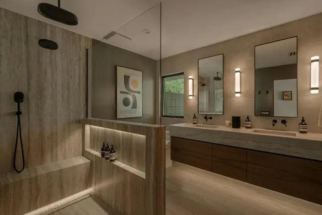 Walk-in shower with travertine-look walls and a long bench